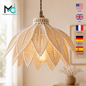 Op de afbeelding: Een crèmekleurige gehaakte hanglamp in de vorm van een bloeiende lotusbloem met puntige bloemblaadjes. De lamp heeft een ingewikkeld opengewerkt patroon, een messingkleurige metalen fitting en een bruin gedraaid snoer aan het plafond.