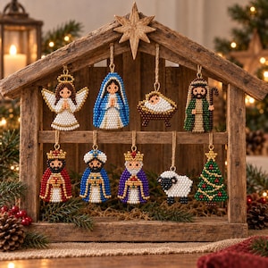 May include: A set of nine beaded Christmas ornaments hanging from a wooden stable structure. The ornaments depict an angel, Mary, baby Jesus in a manger, Joseph, three kings, a sheep, and a Christmas tree, all crafted with colourful glass beads.