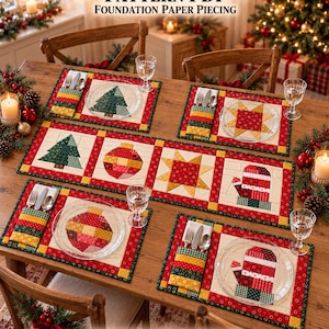 Op de afbeelding: Een kersttafelset patroon PDF voor foundation paper piecing, bestaande uit een tafelloper en vier placemats met bestekzakjes. De doorgestikte stoffen ontwerpen bevatten groene bomen, rode kerstballen, gele sterren en rode wanten.