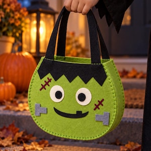 Könnte beinhalten: Eine lindgrüne Filztasche für Süßigkeiten in Form eines Monstergesichts. Die Tasche hat schwarze Filzhaare, zwei weiße runde Augen mit schwarzen Pupillen, einen schwarzen aufgenähten Mund mit einem Zahn, zwei graue Filzschrauben und zwei rote Narben.
