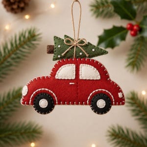 Puede incluir: Un adorno navideño de fieltro con forma de coche rojo con ventanas blancas y ruedas negras. Un árbol de Navidad de fieltro verde con puntos blancos está sujeto al techo con un tronco marrón y un pequeño lazo de cuerda. Cuelga de un cordel.