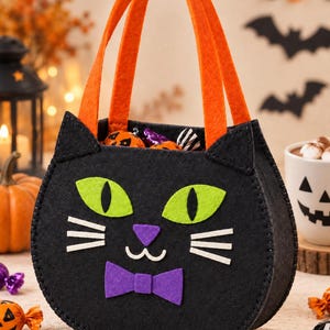 Peut inclure: Un sac à friandises en feutrine noire en forme de chat avec des yeux vert vif, un nez violet, une bouche cousue blanche et un nœud papillon violet. Le sac possède deux anses en feutrine orange et contient des bonbons emballés pour Halloween.