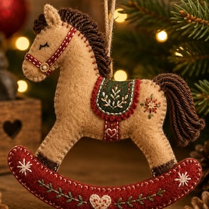Peut inclure: Une décoration de cheval à bascule en feutrine beige avec une crinière et une queue en laine marron foncé. Il présente une selle verte brodée de blanc, une bride rouge avec un petit bouton et une base rouge ornée d'étoiles, de cœurs et de tiges.
