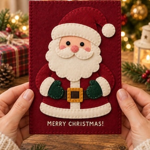 Peut inclure: Une carte de Noël rectangulaire en feutrine rouge foncé avec une applique superposée du Père Noël, dotée d'une barbe blanche, d'un bonnet rouge, de moufles vert foncé et d'une ceinture marron à boucle dorée. Le texte MERRY CHRISTMAS est brodé en blanc.