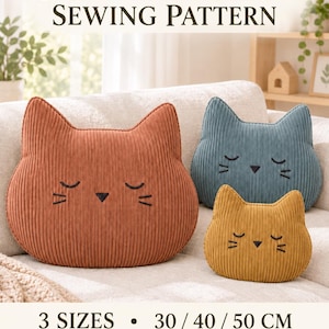 May include: A sewing pattern for a cat head pillow, featuring three sizes: 30, 40, and 50 cm. The image displays three corduroy pillows in rust, blue, and mustard yellow, each with embroidered closed eyes, a nose, and whiskers. Text reads: CAT HEAD PILLOW SEWING PATTERN, 3 SIZES, 30 / 40 / 50 CM, PDF, INSTANT DOWNLOAD.