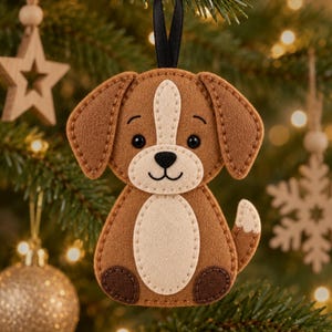 May include: A felt dog ornament featuring a brown body with a cream-colored chest patch, muzzle, and tail tip. The dog has dark brown ears, dark brown paw pads, black embroidered eyes, a black nose, and a black mouth, suspended by a black ribbon.