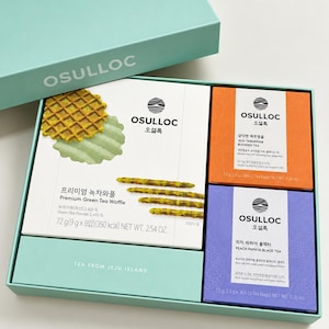 Może przedstawiać: Jasnoniebieskie pudełko prezentowe zawierające produkty marki Osulloc: białe opakowanie wafli z zieloną herbatą, pomarańczowe opakowanie herbaty mandarynkowej z Jeju oraz fioletowe opakowanie czarnej herbaty z brzoskwinią i papają. Tekst: Osulloc.