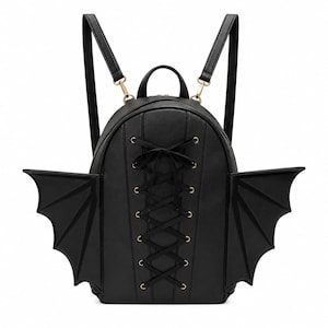 Può includere: Uno zaino nero con due ali prominenti simili a quelle di un pipistrello sui lati. Il pannello frontale presenta un design verticale con allacciatura a corsetto, con nastro nero infilato in occhielli metallici dorati e un fiocco in alto.
