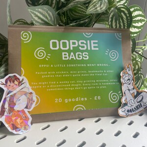 May include: A brown paper bag with a green and yellow label reading OOPSIE BAGS, OPPS! A LITTLE SOMETHING WENT WRONG... Packed with stickers, mini prints, bookmarks & other goodies that didn't quite make the Final Cut. 20 goodies - £6. Two stickers.