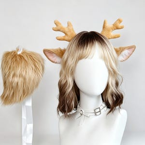 Peut inclure: Un ensemble comprenant un serre-tête avec des bois et des oreilles de cerf en peluche beige, une queue en fausse fourrure beige assortie avec un ruban blanc, et un collier ras-du-cou en similicuir blanc avec des boucles argentées et un nœud.
