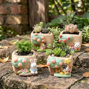 May include: Four square, beige ceramic planters, each featuring a sculpted tree with peach-colored fruit and a small animal figure. The planters contain various green succulents and a small fern, with decorative elements like stars and flowers.