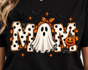 May include: A black t-shirt featuring the word MOM in large white letters with black polka dots. The letter O is replaced by a white ghost wearing an orange polka dot bow. An orange jack-o'-lantern hangs from the letter M, with bats and webs.