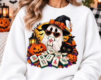 May include: A white sweatshirt featuring a graphic of a ghost wearing a witch hat and heart-shaped sunglasses, holding a mahjong tile. The design includes a black cat, jack-o'-lanterns, a lantern, and scattered mahjong tiles against a yellow moon.