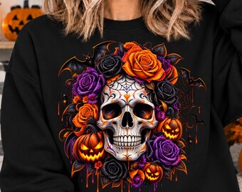 May include: A black sweatshirt featuring a central graphic of a white skull adorned with a spiderweb pattern on the forehead. The skull is surrounded by orange and purple roses, jack-o'-lanterns, and black bats against a dark background.