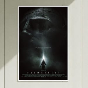 May include: A film poster for Prometheus featuring a large, dark, stone-like head in the background. A small silhouette of a figure stands below, illuminated by a bright beam of light. The text reads: THE SEARCH FOR OUR BEGINNING COULD LEAD TO OUR END.