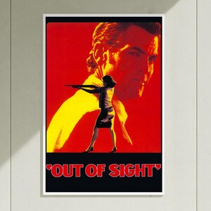 May include: A rectangular movie poster for Out of Sight featuring a large, faded yellow and red portrait of a person in the background. In the foreground, a silhouette of a person in a skirt and top holds a firearm. The title is in red text.