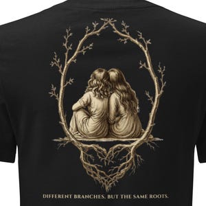 May include: A black short-sleeved t-shirt featuring a graphic on the back of two figures sitting together inside a tree branch frame with visible roots below. The text "DIFFERENT BRANCHES, BUT THE SAME ROOTS." is printed in gold below the illustration.