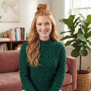 May include: A dark green long-sleeve jumper featuring a prominent cable knit pattern on the front and sleeves, designed with a high mock neck collar and ribbed cuffs, providing a textured appearance with a solid, deep emerald colour throughout.