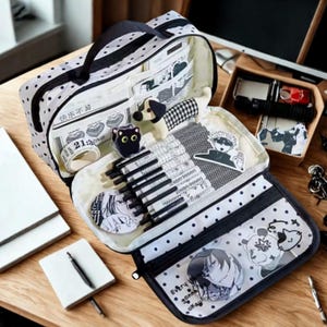 Peut inclure: Une trousse à crayons blanche à pois noirs, dotée de multiples compartiments intérieurs et de poches en filet. Elle contient divers stylos noirs, des autocollants, un rouleau de ruban adhésif et des illustrations d'anime. Poignée et fermeture éclair.