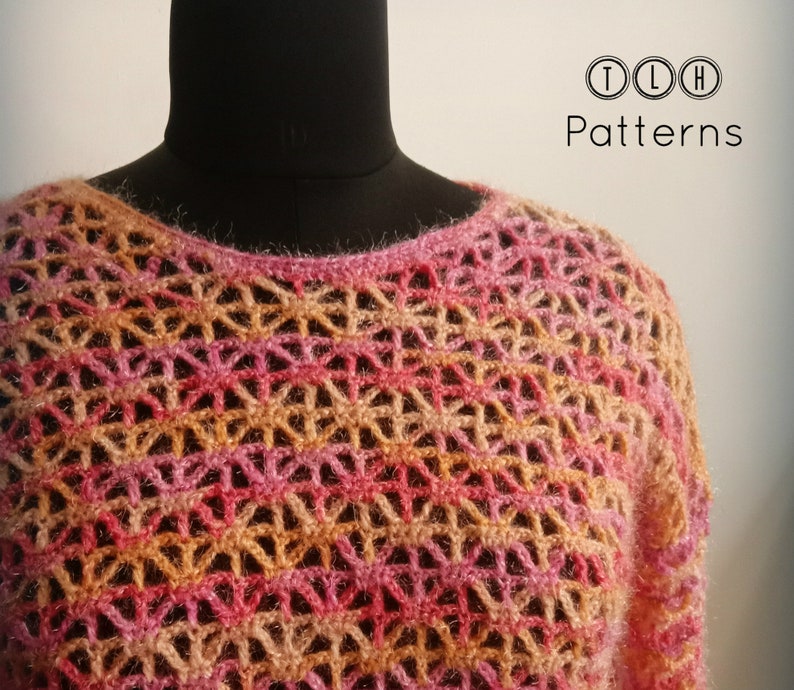 May include: A crocheted top with a lacy pattern in shades of pink, orange, and beige. The top is displayed on a mannequin.