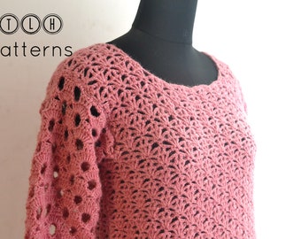 May include: A pink crocheted sweater with a lacy pattern. The sweater has long sleeves and a round neckline.