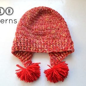 May include: Red and yellow crocheted hat with two pom-poms on the ends of the ear flaps. TLH Patterns.