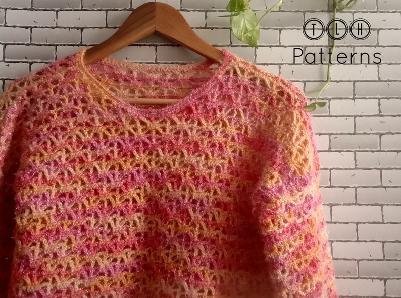May include: A crocheted sweater in a multi-colored ombre pattern of pink, orange, and yellow. The sweater has a loose, open-weave design and a round neckline.