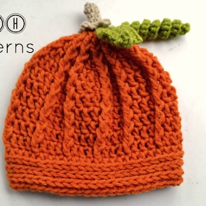 May include: Orange knitted pumpkin hat with a green crocheted stem. The hat has a cable knit pattern and is perfect for fall.