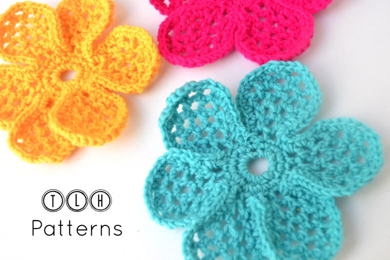 May include: Three crocheted flowers in yellow, pink, and turquoise. The flowers are made with a simple stitch pattern and have a delicate, feminine look.