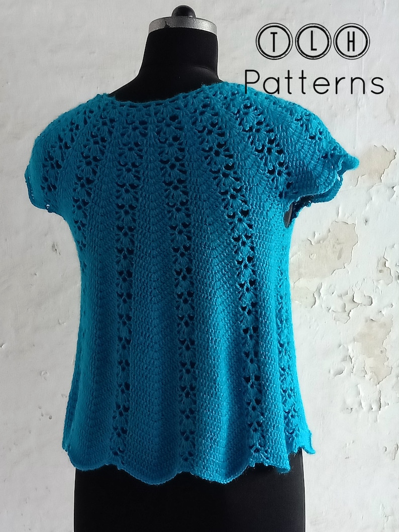 May include: A teal crochet top with a scalloped hem and short sleeves. The top has a delicate openwork pattern.