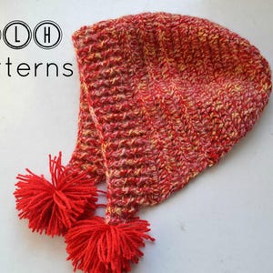 May include: Red and yellow crocheted hat with a pom-pom on the end. TLH Patterns.