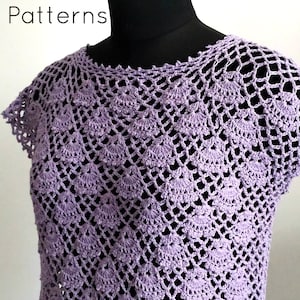 以下が含まれることがあります： 繊細なレース模様のラベンダー色のクロシェトップ。トップは丸首で、袖は短いです。