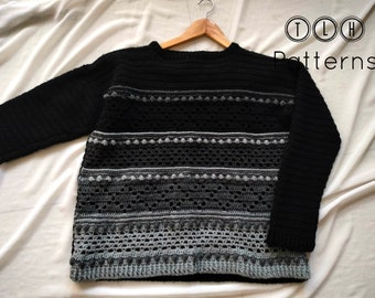 May include: A black crochet sweater with grey and white stripes and a crocheted pattern. The sweater has a round neckline and long sleeves. The sweater is hanging on a wooden hanger. The text "TLH Patterns" is visible in the top right corner of the image.