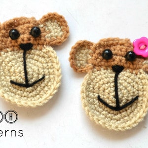 May include: Two crocheted monkey faces, one with a pink flower button. The monkey faces are brown and beige with black eyes and a black stitched mouth.