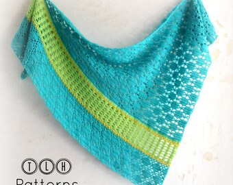 May include: A teal crochet shawl with a green and yellow stripe. The shawl is hanging on a white wall. The text "TLH Patterns" is visible in the bottom left corner of the image.