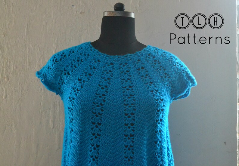 May include: A turquoise crochet top with a delicate openwork pattern. The top has short sleeves and a round neckline. TLH Patterns is printed on the background.