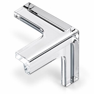 May include: A clear, transparent L-shaped corner protector made of solid material. The object features a smooth, polished surface with defined right-angle edges and a hollow interior channel designed to fit snugly over the corner of a flat surface.