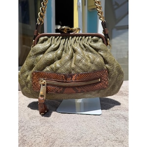 Peut inclure: Un sac à main texturé vert olive avec un haut froncé, une bandoulière en chaîne métallique dorée et une poche horizontale zippée à motif peau de serpent marron sur le devant. Le sac présente une fermeture à fermoir doré et des bordures en cuir marron.