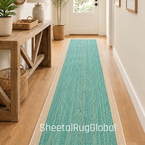 Puede incluir: Una alfombra de pasillo rectangular larga con un panel central de color azul turquesa vibrante con un acabado tejido texturizado, enmarcado por un borde ancho de color beige sólido. La alfombra está sobre un suelo de madera y muestra el texto SheetalRugGlobal.