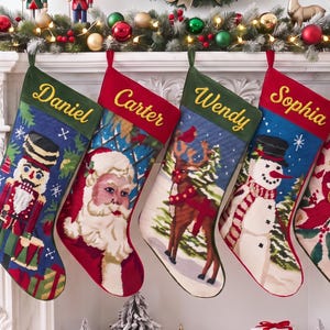 Peut inclure: Cinq chaussettes de Noël personnalisées suspendues en rangée, chacune avec un motif de fête unique incluant un casse-noisette, le Père Noël, un renne, un bonhomme de neige et des sucres d'orge, avec les noms Daniel, Carter, Wendy, Sophia et Rachel.