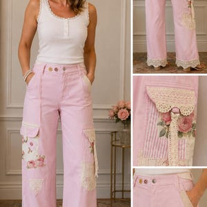 May include: Light pink wide-leg pants featuring cream-colored lace trim at the hems and pockets. The pants include side cargo pockets decorated with floral and striped fabric patches, lace accents, and a button-front closure with a waistband.