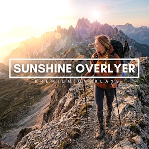 May include: A hiker wearing a rust-colored jacket, dark leggings, and a backpack, holding trekking poles on a rocky mountain ridge. The image features the text SUNSHINE OVERLYER and PREMIUM OVERLAYS against a bright, sunlit mountain landscape.