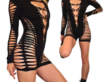 May include: Black long-sleeved bodysuit with a lace-up front and cutouts throughout. The bodysuit is made of a stretchy fabric and has a fitted silhouette.