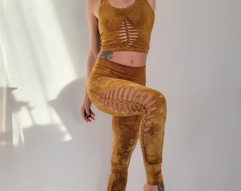 May include: A mustard yellow crop top and leggings set with a unique braided design. The top has a scoop neck and the leggings have a high waist.