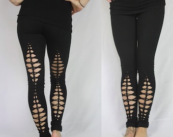 Puede incluir: Leggings negros con diseños recortados en las piernas. Los leggings están hechos de una tela elástica y tienen un ajuste cómodo.