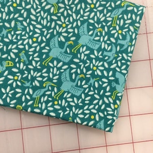 May include: Teal fabric with a white and yellow pattern of birds and leaves.