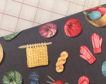 May include: A dark gray fabric with a repeating pattern of yarn balls, knitting needles, and mittens. The yarn balls are in various colors, including red, blue, green, and purple. The knitting needles are silver and the mittens are red and white.