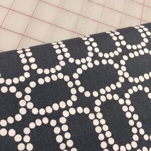 May include: Dark blue fabric with a white geometric pattern of circles arranged in a repeating design.