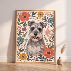 Pode incluir: Uma impress&atilde;o de arte emoldurada apresentando um c&atilde;o Schnauzer cinza cercado por uma borda floral colorida com flores vermelhas, amarelas, rosas e azuis e folhas verdes. A palavra BARKLINE est&aacute; impressa em letras pequenas e claras no topo.