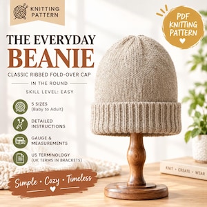Puede incluir: Un gorro de punto beige con un borde acanalado doblado sobre un soporte de madera. El texto dice: Knitting Pattern, The Everyday Beanie, Classic Ribbed Fold-Over Cap, In The Round, Skill Level: Easy, 5 Sizes, Detailed Instructions, Gauge & Measurements, US Terminology, Simple, Cozy, Timeless.